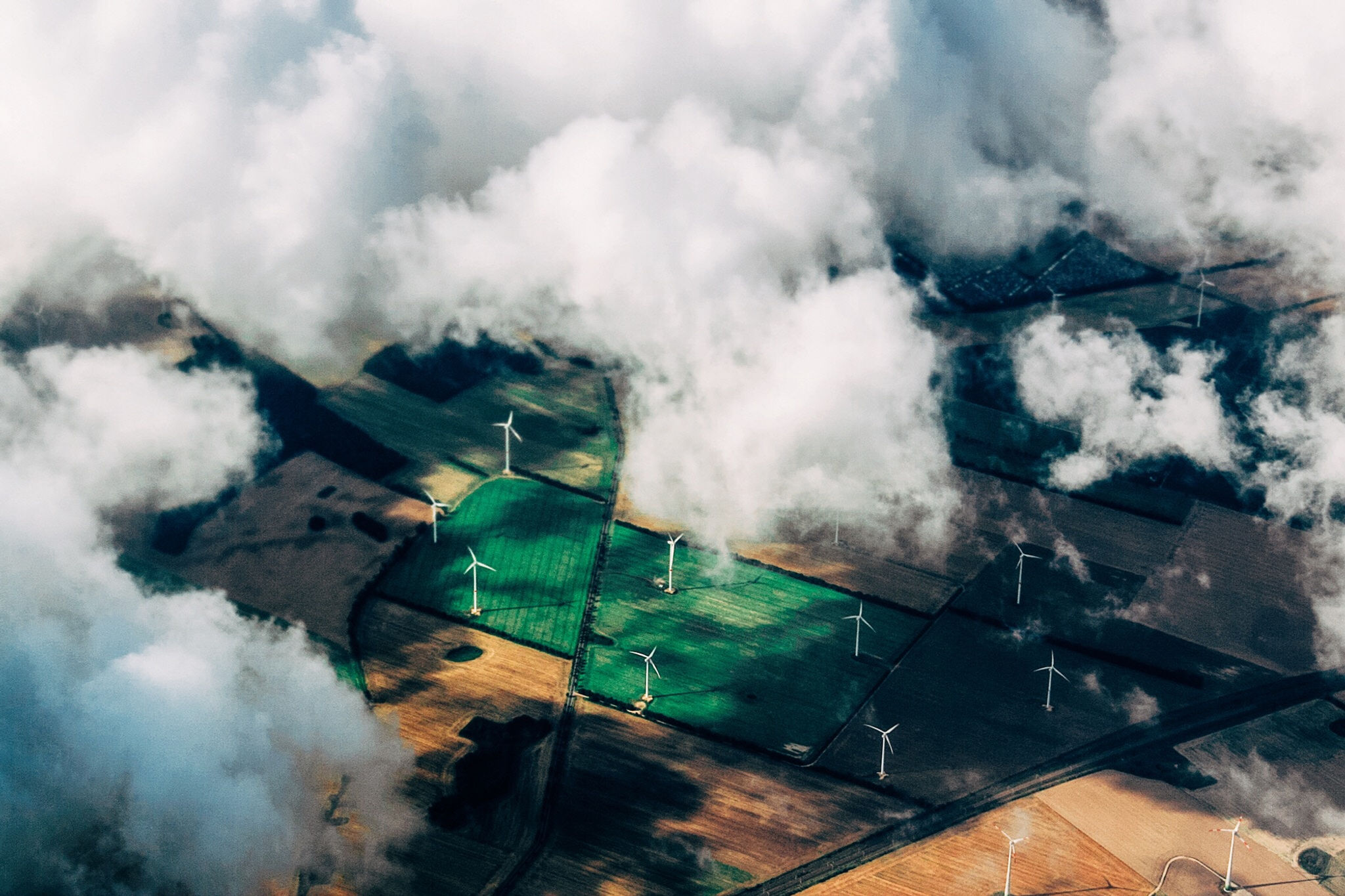 Wind turbines on a rural landscape under a partly cloudy sky